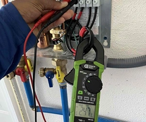 Technician Testing Electrical Wiring With Clamp Meter At Southwest Florida